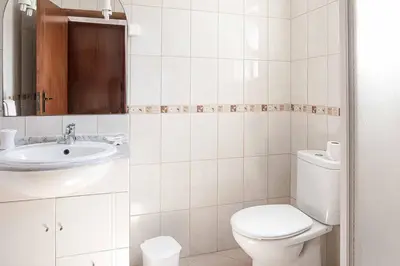 a white bathroom with a toilet and a sink at Villa Cesaltina in Guia