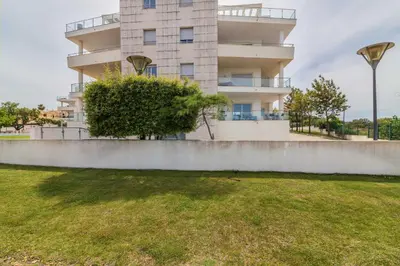 a building with a grass field in front of it at Penthouse Monte da Eira - Sunset in Albufeira