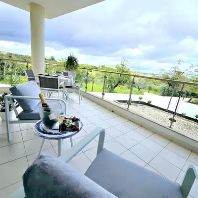 a balcony with a table with a bottle of champagne on it at T1 Albufeira Tranquilidade in Albufeira