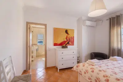 a bedroom with a bed and a painting on the wall at Breeze Villa - Adults Only in Albufeira