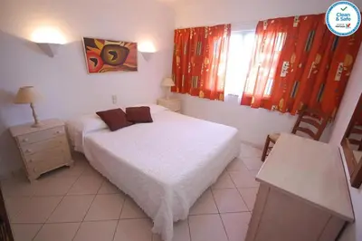 a bedroom with a bed and a table and a chair at Solar dos Vilarinhos - By bedzy in Albufeira