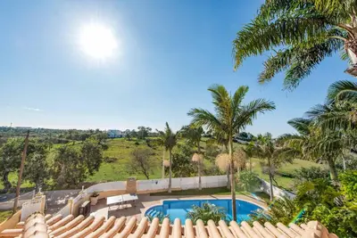 a house with a swimming pool and palm trees at Villa Caty Catarina in Albufeira
