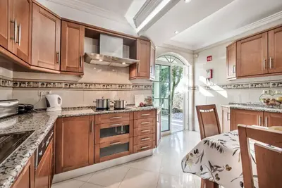 a large kitchen with wooden cabinets and a table in it at Villa Caty Catarina in Albufeira