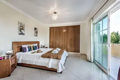 a bedroom with a large bed and a large window at Villa Caty Catarina in Albufeira
