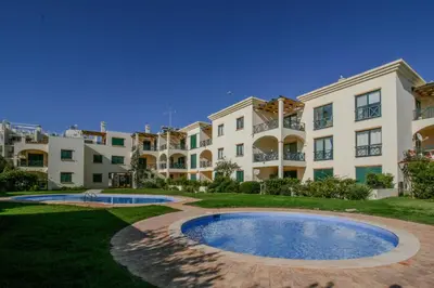 an apartment building with a large pool in front of it at FLH Olhos D' Água Apartment with Pool in Albufeira