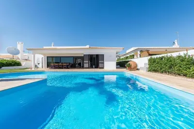 a swimming pool in front of a house at Villa Casa Amendoeiras by LovelyStay in Albufeira