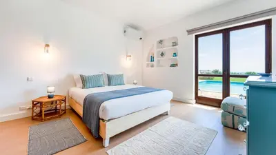 a bedroom with a bed and a large window at Villa Casa Amendoeiras by LovelyStay in Albufeira