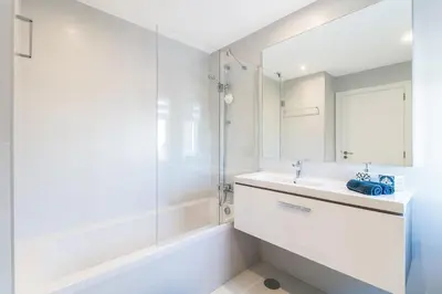 a bathroom with a sink and a tub and a mirror at Family Villa 3 Bedrooms private rooftop with Pool in Albufeira