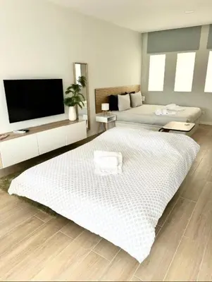 a bedroom with two beds and a flat screen tv at Alagoas Studio - City Center in Faro