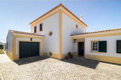 a large white house with a garage at Villa Império in Albufeira