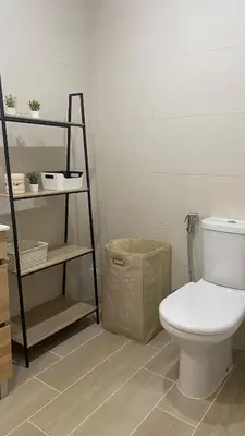 a bathroom with a toilet and a shelf at Apartamento 5 min a pé da praia, com terraço ao sol, no 1º andar in Quarteira