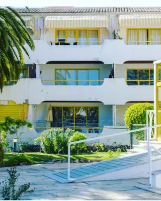 a white building with stairs in front of it at Apartamento 5 min a pé da praia, com terraço ao sol, no 1º andar in Quarteira