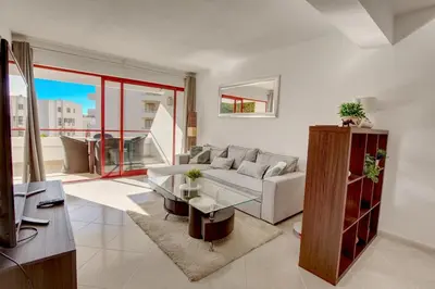 a living room with a couch and a table at Vacation Apartment in Vilamoura in Quarteira
