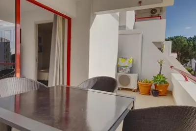 a dining room with a table and chairs on a balcony at Vacation Apartment in Vilamoura in Quarteira