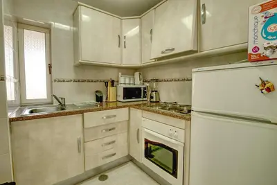 a kitchen with white cabinets and a white refrigerator at Vacation Apartment in Vilamoura in Quarteira