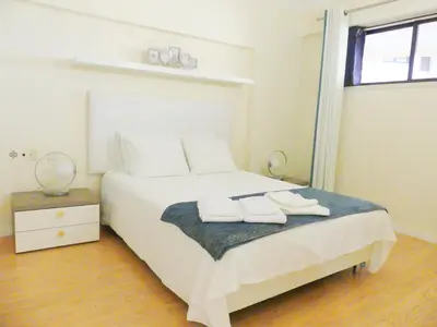 a bedroom with a bed with two white shoes on it at MarinaMar Vilamoura Sea View in Quarteira