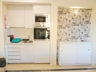 a kitchen with white cabinets and a microwave at MarinaMar Vilamoura Sea View in Quarteira