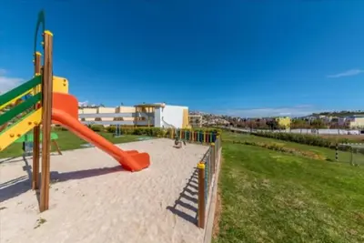 a playground with an orange slide in a park at Albufeira Marina Gardens AO in Albufeira