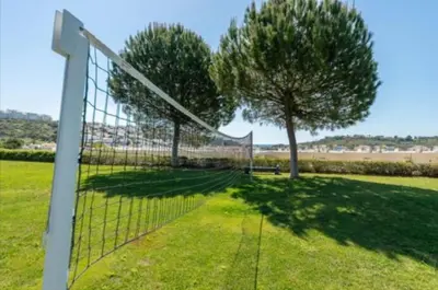 a volley ball net in a field with a tree at Albufeira Marina Gardens AO in Albufeira