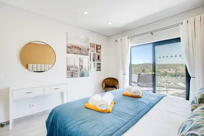a bedroom with a blue bed with towels on it at Quinta do Cerro in Loulé