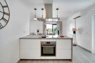 a kitchen with white cabinets and a stove at Quinta do Cerro in Loulé