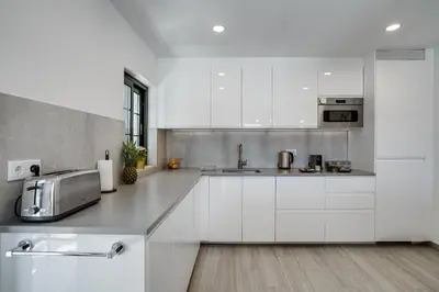 a white kitchen with white cabinets and a sink at Quinta do Cerro in Loulé