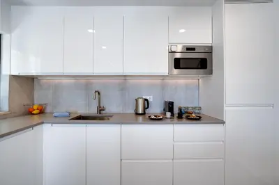 a white kitchen with a sink and a microwave at Quinta do Cerro in Loulé