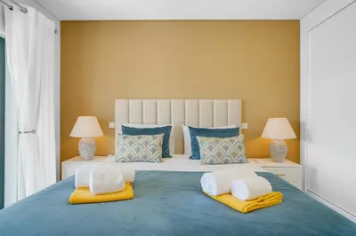 a bedroom with a large blue bed with two lamps at Quinta do Cerro in Loulé