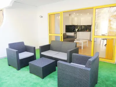 a living room with couches and chairs and a kitchen at Romao Marina Vilamoura in Quarteira
