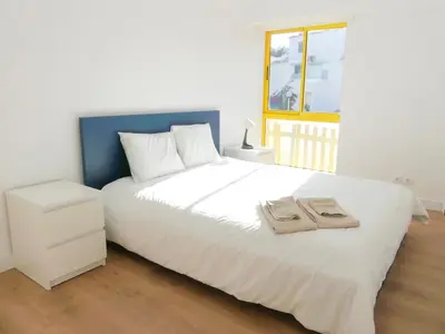 a bedroom with a white bed with two towels on it at Romao Marina Vilamoura in Quarteira
