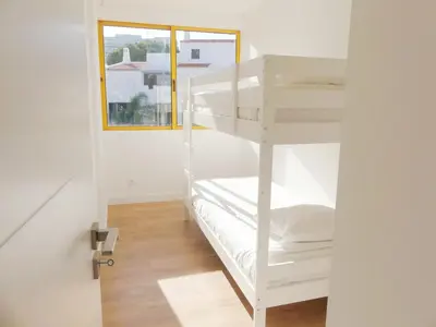 a white bunk bed in a room with a window at Romao Marina Vilamoura in Quarteira