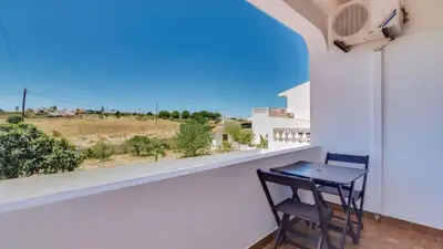 a table and chair on a balcony with a view at Villa Rique in Albufeira