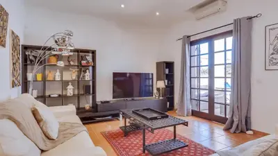 a living room with a white couch and a tv at Villa Rique in Albufeira