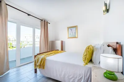 a bedroom with a bed and a balcony at Atlantic Apartment in Albufeira