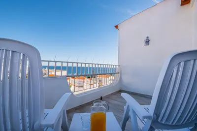 a balcony with two chairs and a table with orange juice at Atlantic Apartment in Albufeira