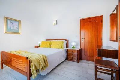 a bedroom with a bed and a desk and a piano at Atlantic Apartment in Albufeira