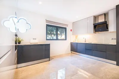 a large kitchen with blue cabinets and a window at Old Town Charm Apartment in Albufeira