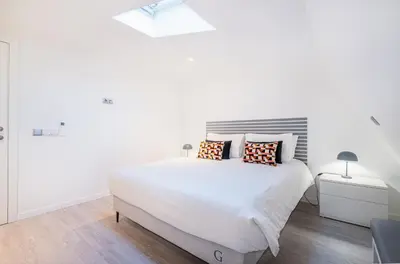 a white bedroom with a large white bed with pillows at Old Town Charm Apartment in Albufeira