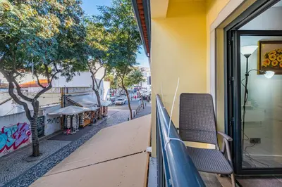 a balcony of a building with a bench on a street at Old Town Charm Apartment in Albufeira