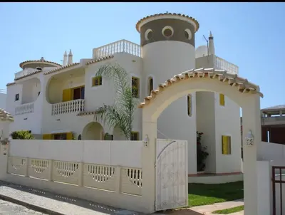 a white house with an arch and a fence at Casa Maré Alta in Guia