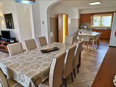 a dining room and kitchen with a table and chairs at Casa Maré Alta in Guia