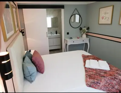 a bedroom with a white bed and a bathroom at Casa Maré Alta in Guia