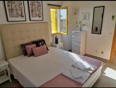a bedroom with a large white bed with pink pillows at Casa Maré Alta in Guia