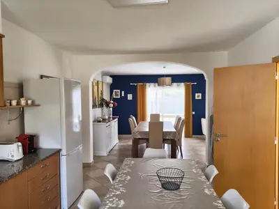 a kitchen with a table and a dining room at Casa Maré Alta in Guia