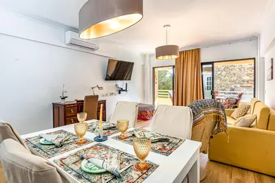 a living room with a table and chairs at 2 Bed-Sleeps 4-Vilamoura Beach-Pool-Spa-Balcony in Quarteira