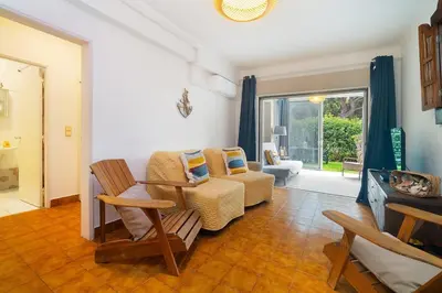 a living room with a couch and a chair at Sardinha Beach House in Olhos de Água