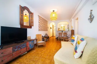 a living room with a couch and a tv at Sardinha Beach House in Olhos de Água