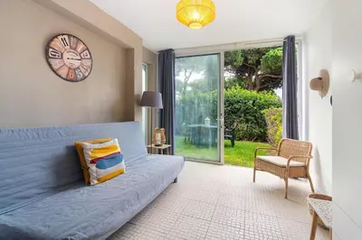 a bedroom with a blue bed and a clock on the wall at Sardinha Beach House in Olhos de Água