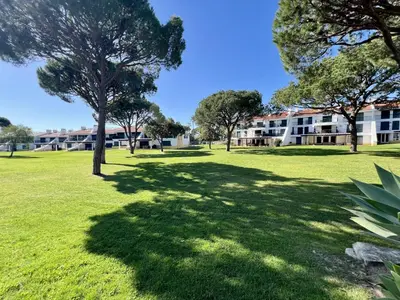 a park with trees and a building in the background at Vilamoura Sunny Garden With Pool by Homing in Vilamoura