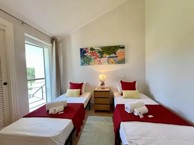 two twin beds in a room with a window at Vilamoura Sunny Garden With Pool by Homing in Vilamoura